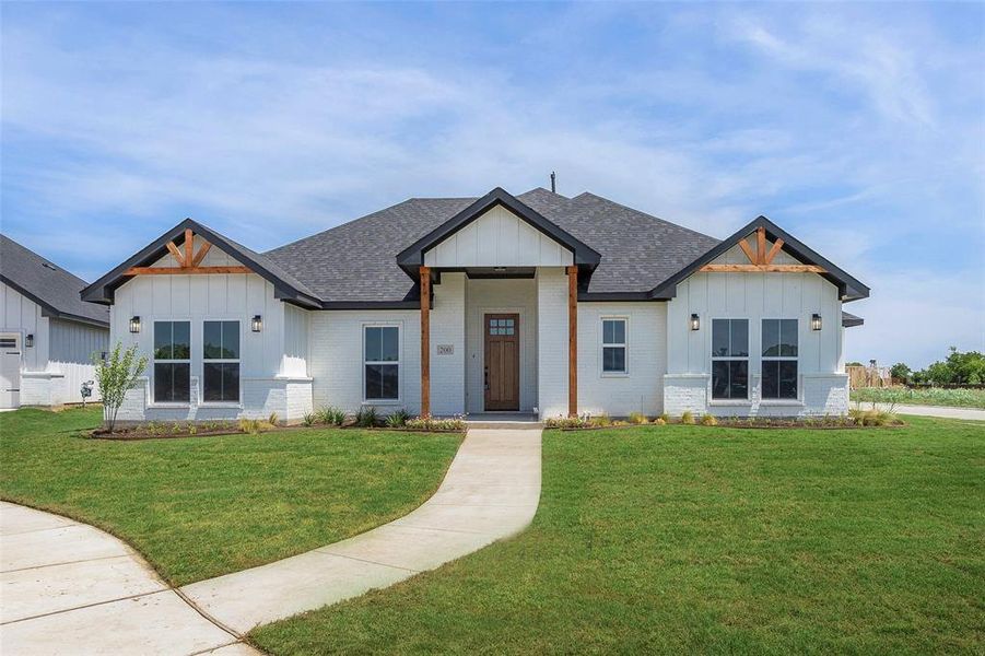 Modern farmhouse style home with a front lawn