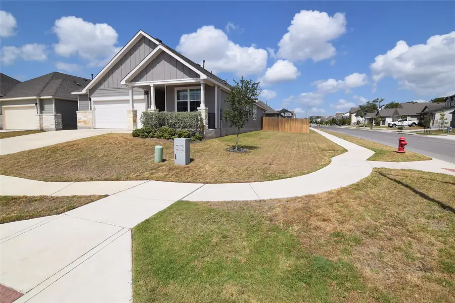 Neat concrete sidewalks trace the corner lawn of this modern suburban home.