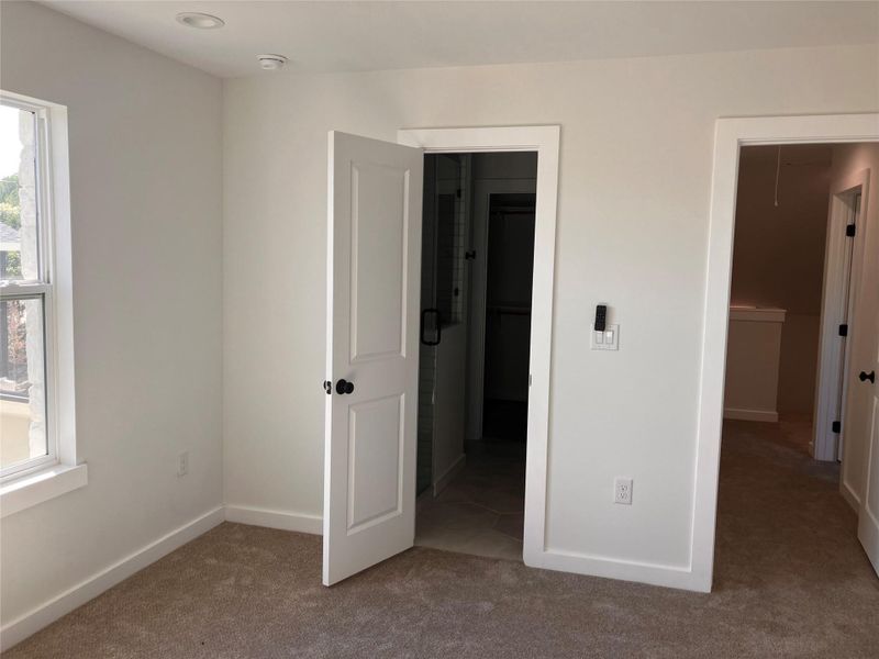 Unfurnished bedroom with carpet floors, attic access, and a spacious closet