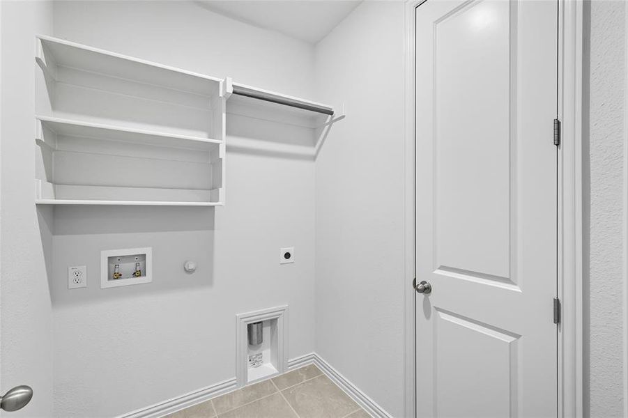 Laundry area with gas dryer hookup, light tile patterned floors, electric dryer hookup, and hookup for a washing machine Laundry area with gas dryer hookup, light tile patterned floors, electric dryer hookup, and hookup for a washing machine