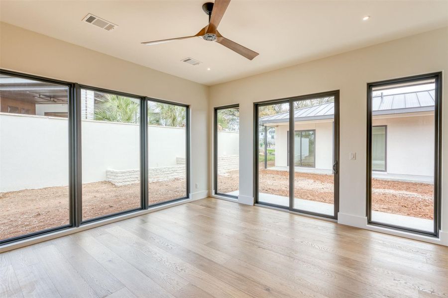 Primary suite with wall of windows overlooks courtyard