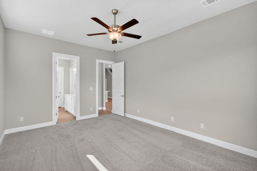 Unfurnished bedroom featuring light carpet, ceiling fan, and ensuite bathroom Unfurnished bedroom featuring light carpet, ceiling fan, and ensuite bathroom
