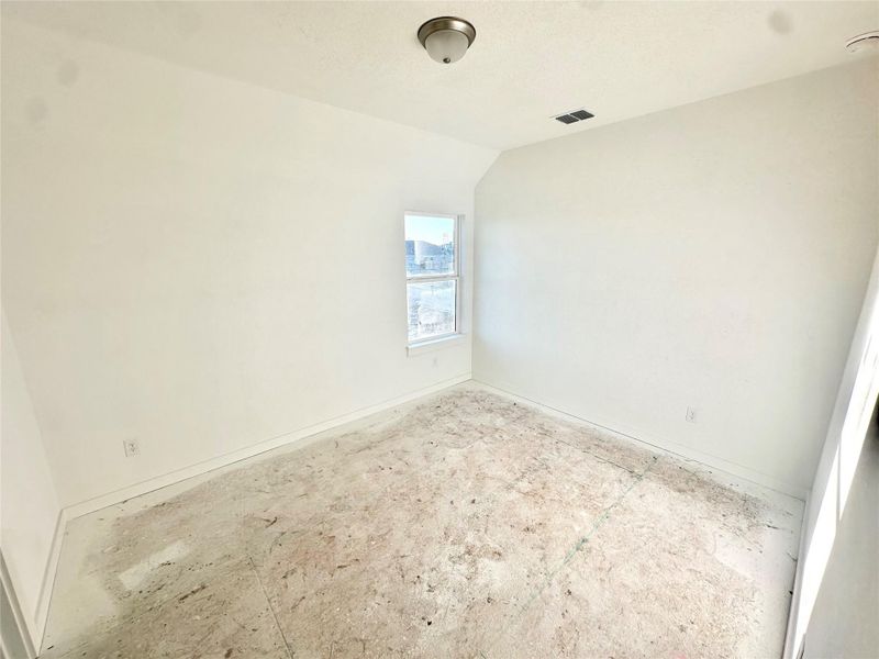Spare room featuring lofted ceiling