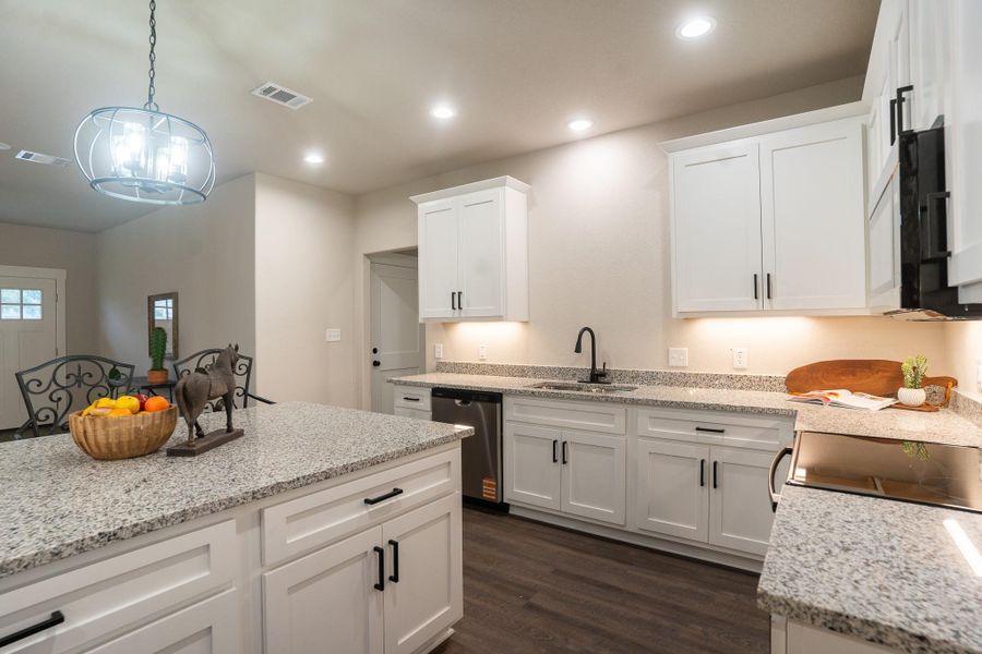 Kitchen featuring a sink, dishwasher, dark wood-type flooring, white cabinets, and pendant lighting Kitchen featuring a sink, dishwasher, dark wood-type flooring, white cabinets, and pendant lighting