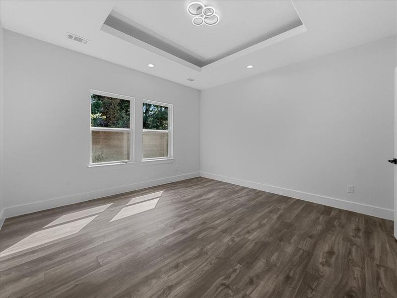 Unfurnished room featuring a raised ceiling, dark wood finished floors, and recessed lighting Unfurnished room featuring a raised ceiling, dark wood finished floors, and recessed lighting