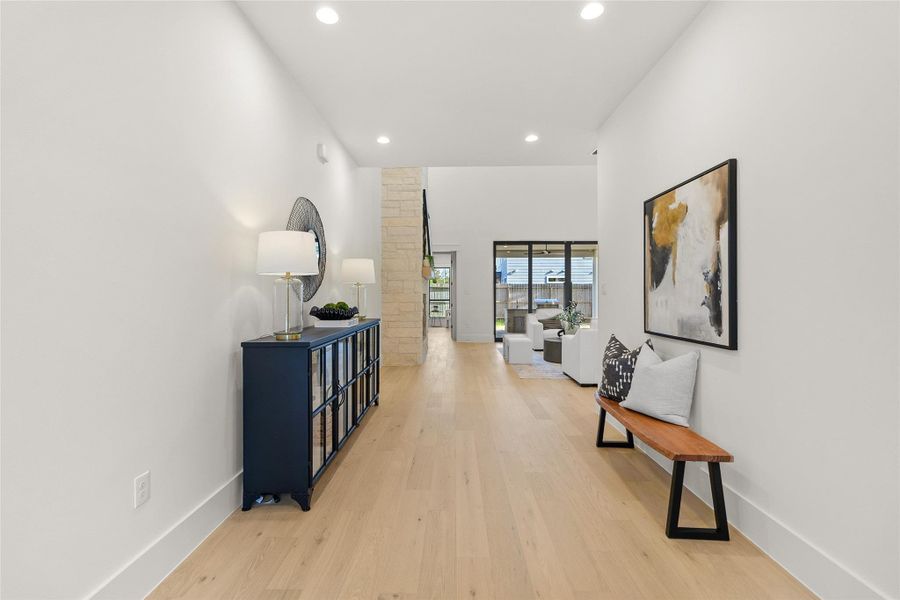 Coming home begins with a welcoming entry that sets the tone, featuring clean architectural lines, wide-plank flooring, and an inviting view into the heart of the home.