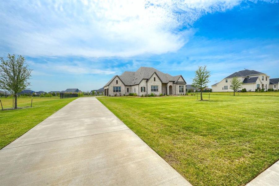 French country style house with stone siding, a front lawn, and a residential view