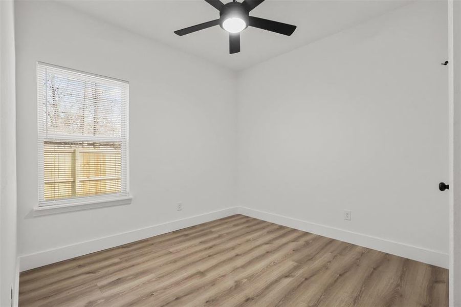 Empty room with light wood-type flooring and ceiling fan