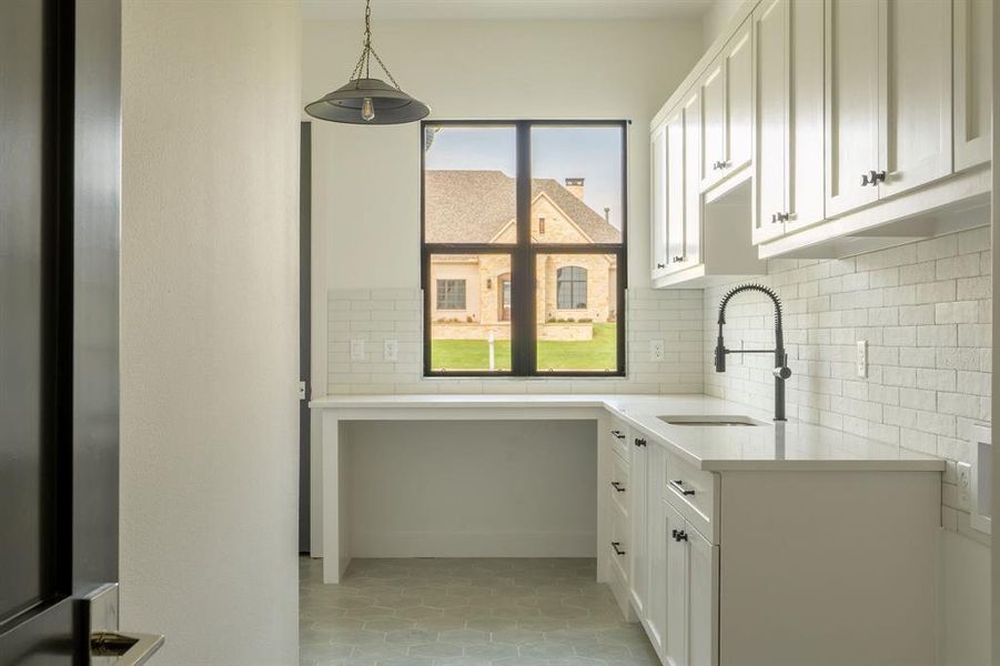 Laundry area with a sink and light tile patterned floors Laundry area with a sink and light tile patterned floors