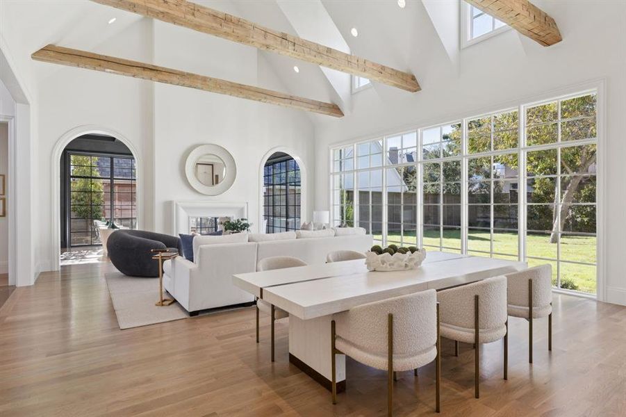 Dining area featuring high vaulted ceiling, light wood-style floors, beam ceiling, and recessed lighting