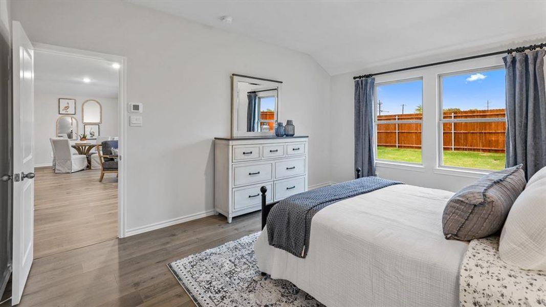 Bedroom with vaulted ceiling and dark wood-style floors Bedroom with vaulted ceiling and dark wood-style floors