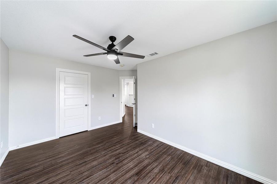 Unfurnished bedroom with dark wood finished floors, ceiling fan, and a closet