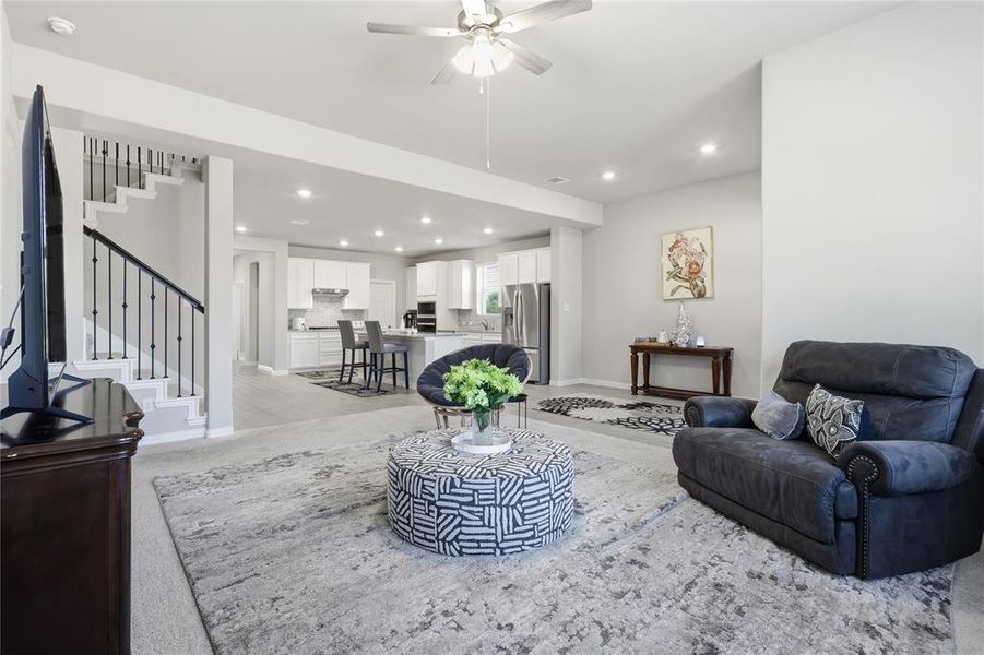 Open-concept living space featuring recessed lighting, a modern ceiling fan, and light-colored wall finishes