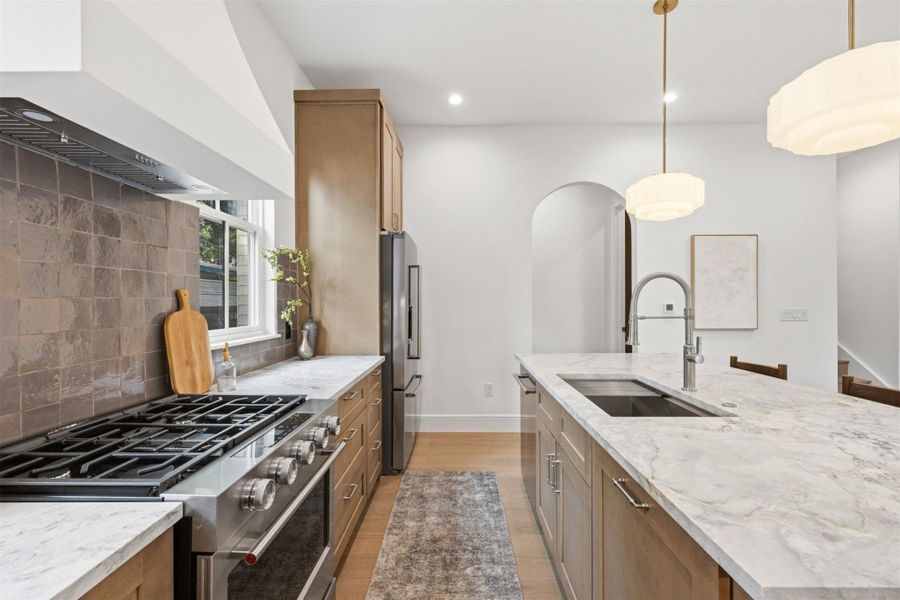 Culinary aspirations meet design in this well-appointed kitchen featuring a substantial island with a sink.