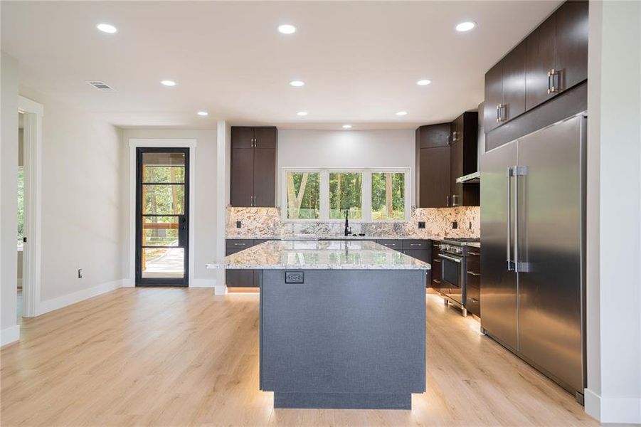 Kitchen with premium appliances, a kitchen island, healthy amount of natural light, tasteful backsplash, and recessed lighting Kitchen with premium appliances, a kitchen island, healthy amount of natural light, tasteful backsplash, and recessed lighting