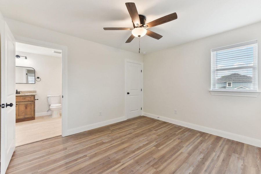 Bedroom 3 featuring a ceiling fan, ensuite bathroom, light wood-style floors, baseboards, and visible vents