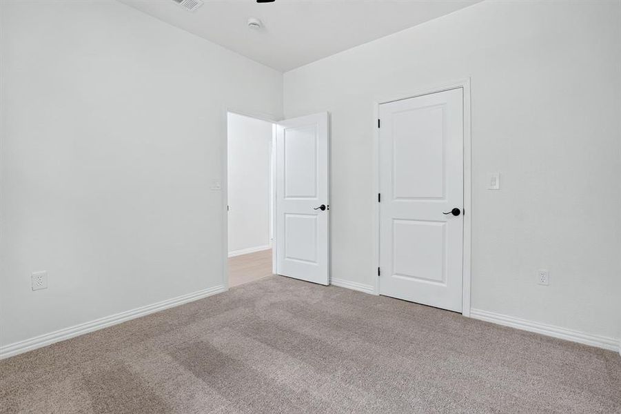 Neutral tone walls with white trim and gray carpeting