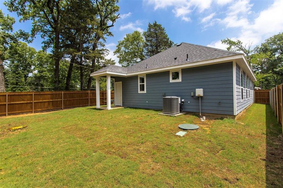 Back of property featuring a yard and central AC