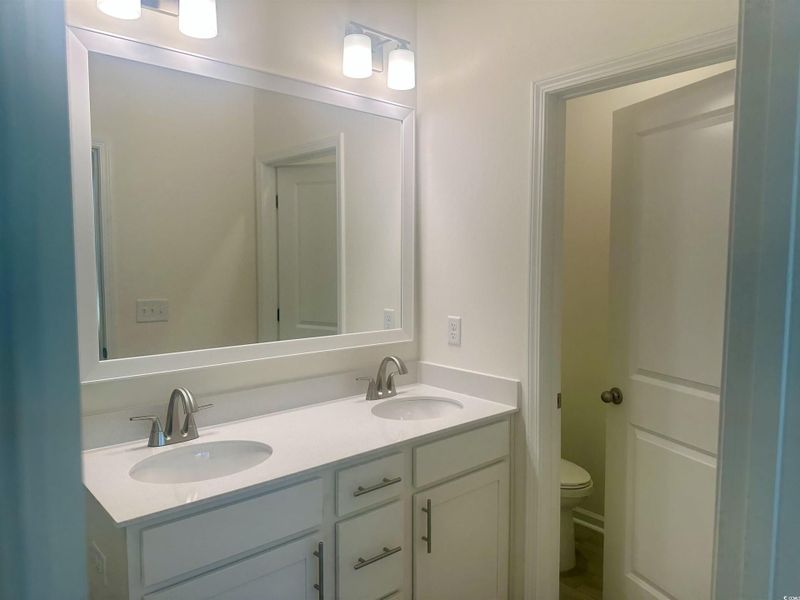 Full bathroom with double vanity and toilet
