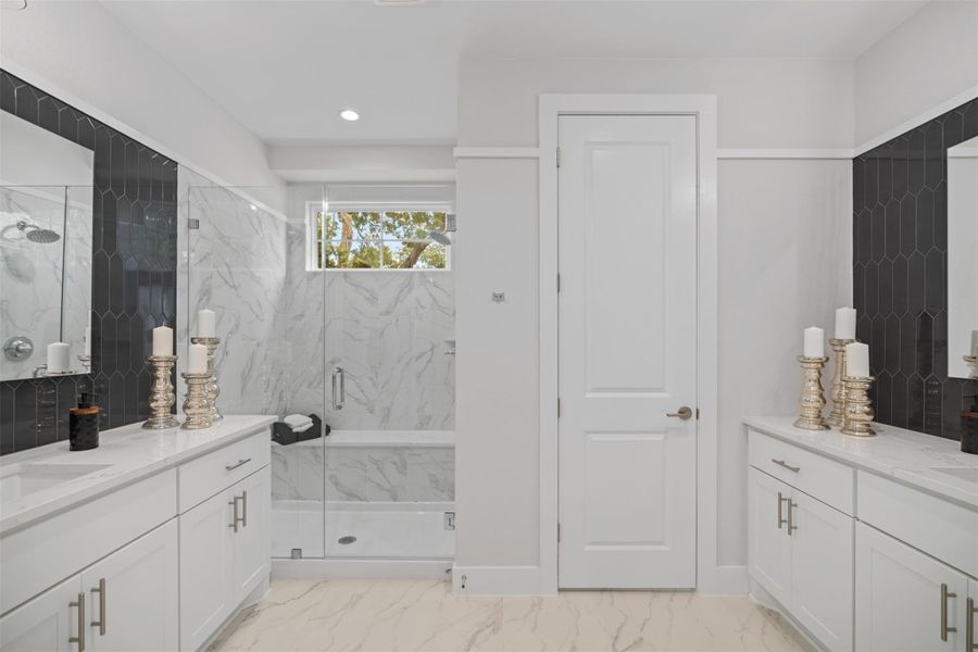 Full bath featuring a marble finish shower, vanity, marble finish floors, and recessed lighting. The photos shown are of a completed home with the same floor plan and may not reflect the exact finishes, features, or layout of the home currently under construction.
