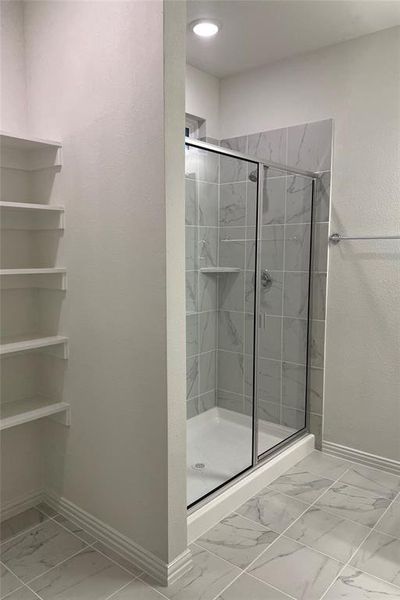 Full bathroom with light marble finish flooring and a shower stall Full bathroom with light marble finish flooring and a shower stall