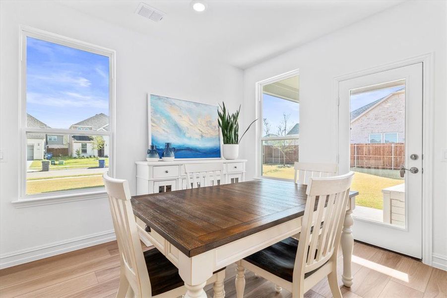 Dining space with light wood finished floors and recessed lighting