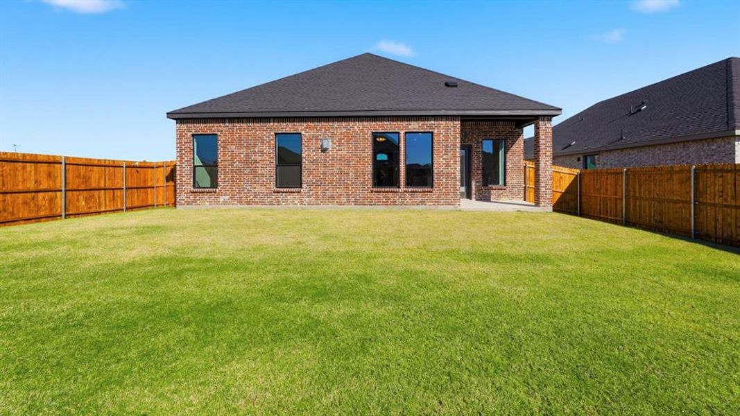 Back of house with a patio, brick siding, a fenced backyard, and a shingled roof