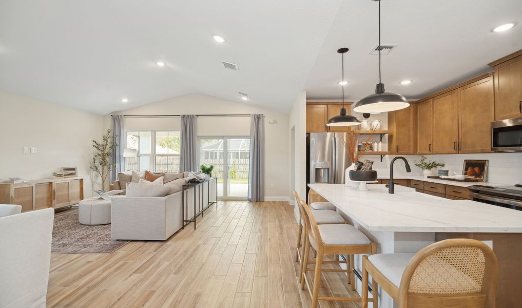Kitchen overlooking great room and dining area with vaulted ceiling