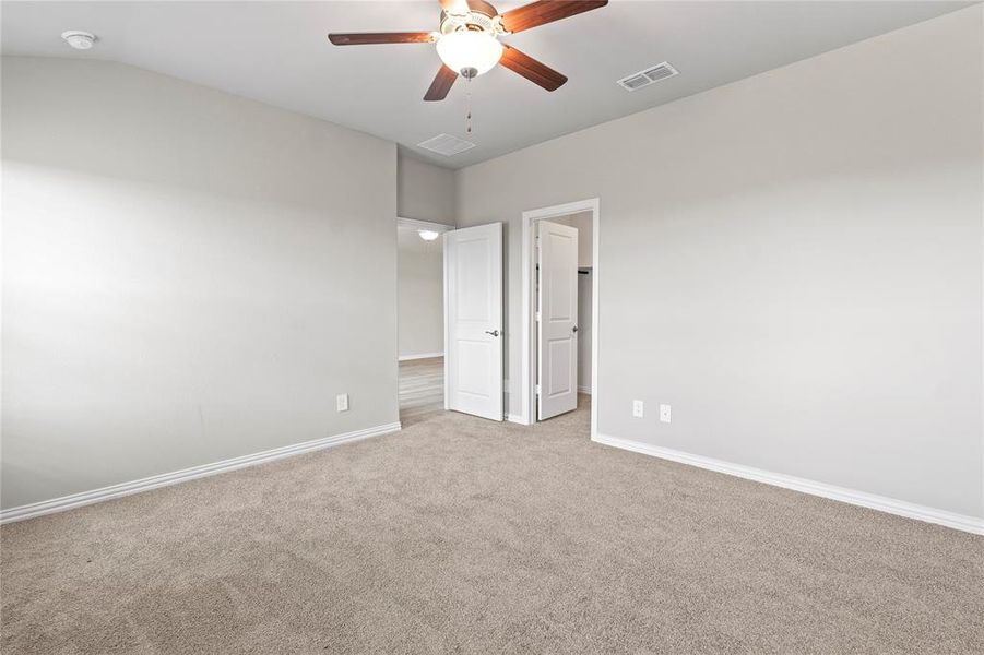 Unfurnished bedroom featuring carpet, ceiling fan, and vaulted ceiling Unfurnished bedroom featuring carpet, ceiling fan, and vaulted ceiling