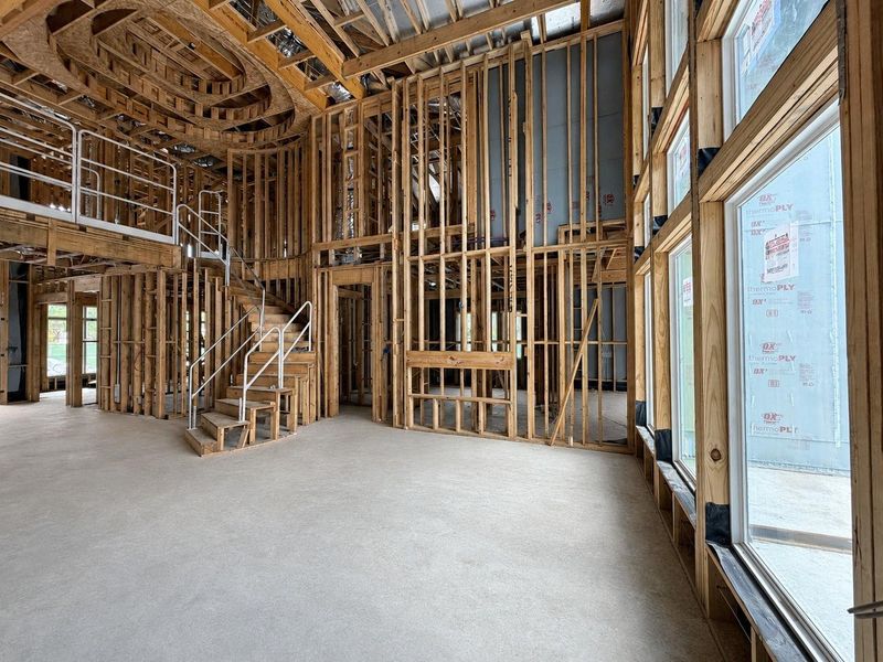 Living Area That Features High Ceilings, Natural Light, and An Electric Fireplace. Construction photo as of 08/18/2026