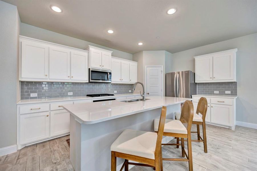 Amazing Kitchen with gas cooktop, white quartz and stainless appliances.