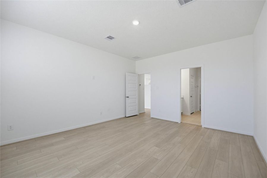 Additional view of the primary bedroom looking towards the primary bathroom.