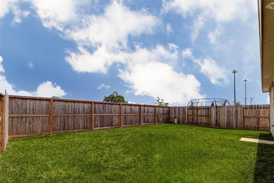 Fully fenced backyard offering plenty of green space for entertaining, pets, or outdoor activities.