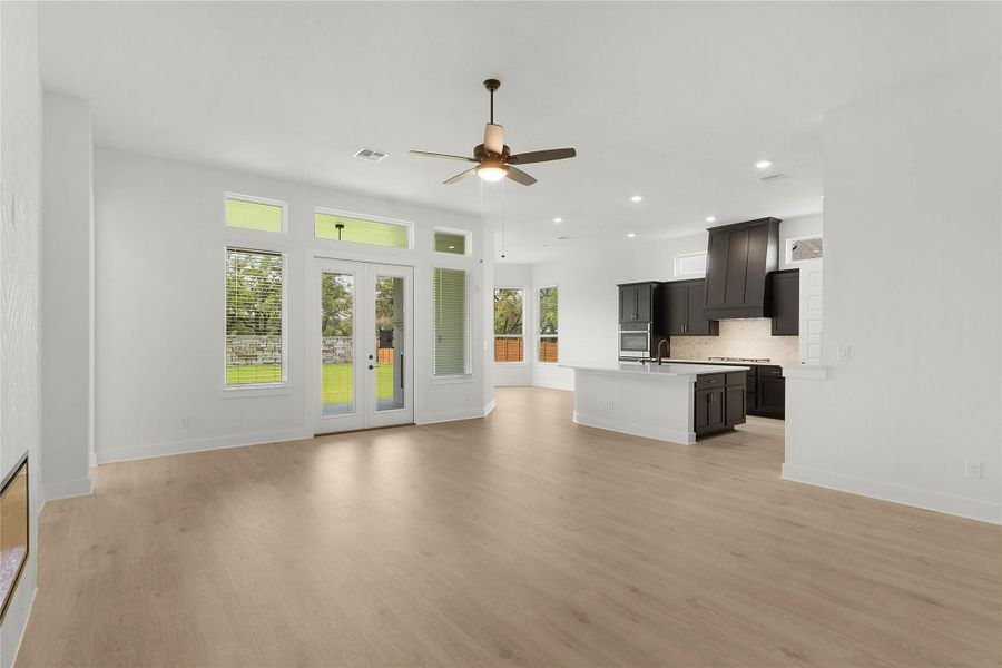 Unfurnished living room featuring ceiling fan, light wood-style flooring, and recessed lighting Unfurnished living room featuring ceiling fan, light wood-style flooring, and recessed lighting