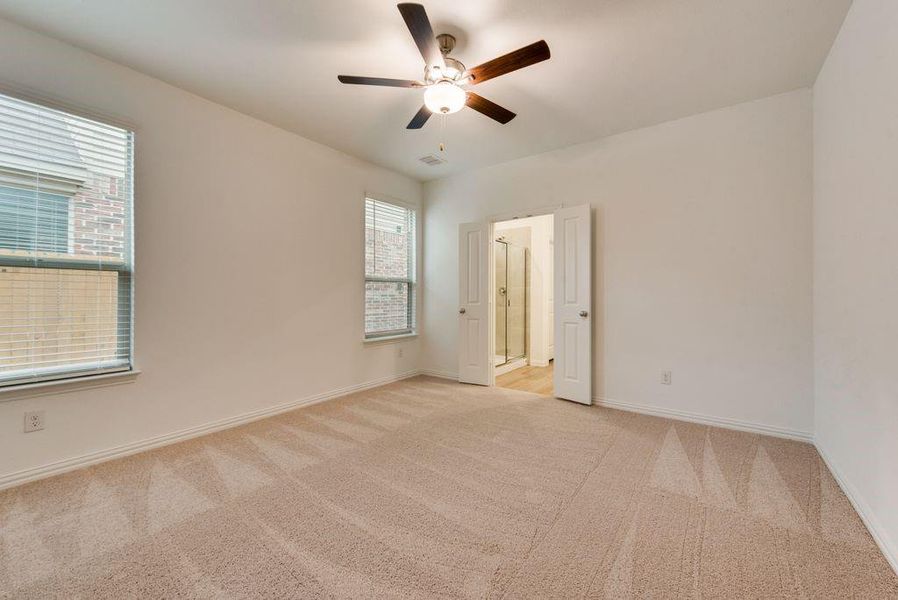 Carpeted spare room featuring ceiling fan