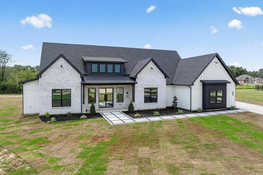 View of front of home with board and batten siding, a shingled roof, and a front yard View of front of home with board and batten siding, a shingled roof, and a front yard