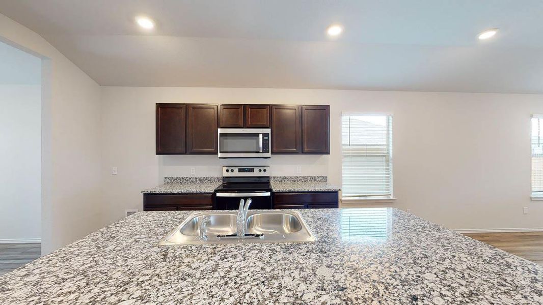 Kitchen island featuring a double basin stainless steel sink with a chrome faucet