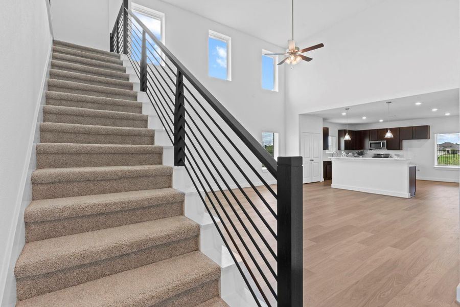 Sleek modern staircase with contemporary wrought iron railing creates a striking architectural focal point and connects to the expansive upstairs game room. **Image Representative of Plan Only and May Vary as Built**. Sleek modern staircase with contemporary wrought iron railing creates a striking architectural focal point and connects to the expansive upstairs game room. **Image Representative of Plan Only and May Vary as Built**.