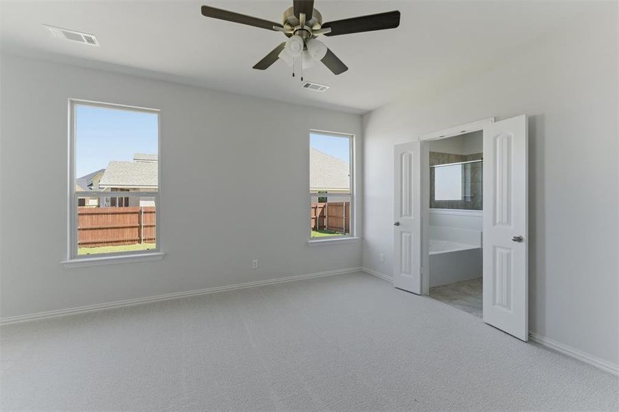 Unfurnished bedroom featuring light colored carpet and ceiling fan