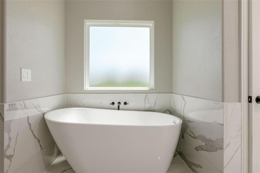 Bathroom with tile walls, a soaking tub, and wainscoting Bathroom with tile walls, a soaking tub, and wainscoting