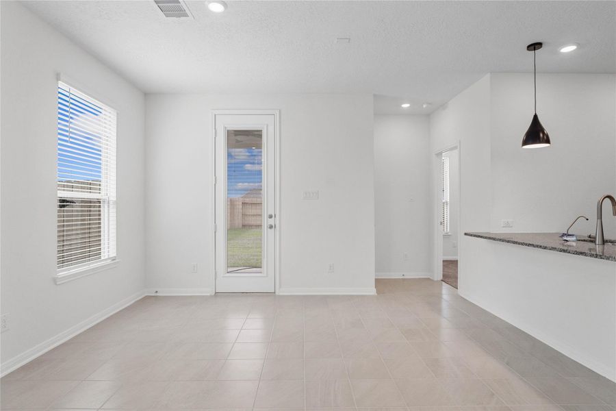 Create lasting memories with family and friends in this inviting dining room! It showcases high ceilings, recessed lighting, custom paint, stunning ceramic tile flooring, large window with privacy blinds, and access door with blind insert to the rear patio and backyard! Create lasting memories with family and friends in this inviting dining room! It showcases high ceilings, recessed lighting, custom paint, stunning ceramic tile flooring, large window with privacy blinds, and access door with blind insert to the rear patio and backyard!