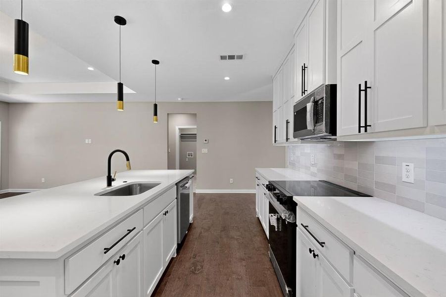 Kitchen featuring stainless steel appliances, light stone countertops, white cabinets, and recessed lighting Kitchen featuring stainless steel appliances, light stone countertops, white cabinets, and recessed lighting