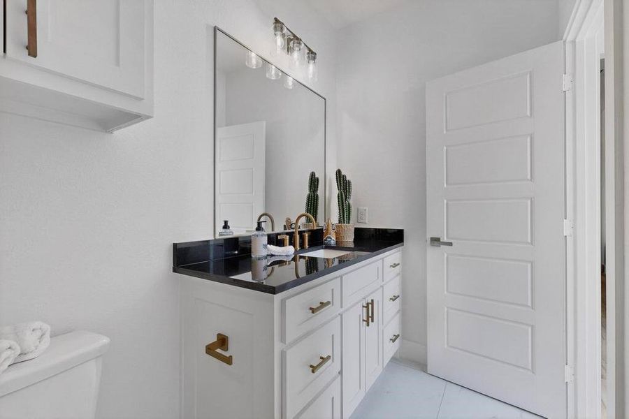 Half bathroom featuring vanity and toilet