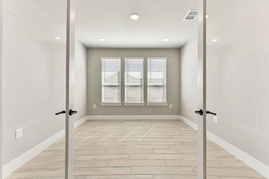 Empty room featuring french doors, light wood-type flooring, and recessed lighting