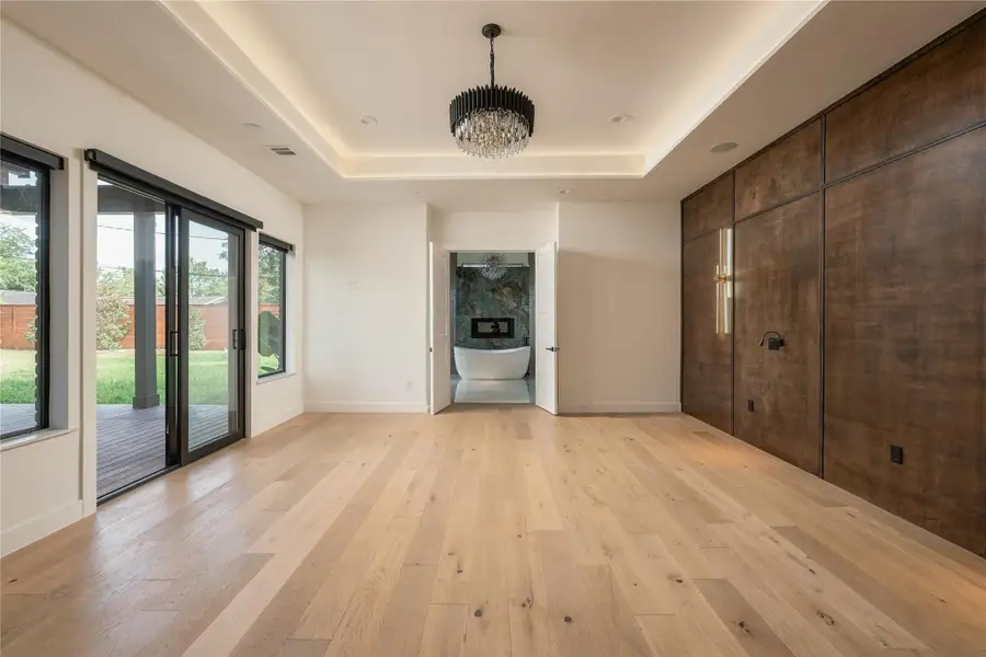 Primary Bedroom with Custom Wood Accents, Lighting, and Backyard Access