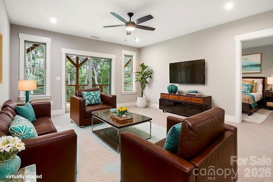 Lower level rec room opening to large covered deck overlooking wooded view.