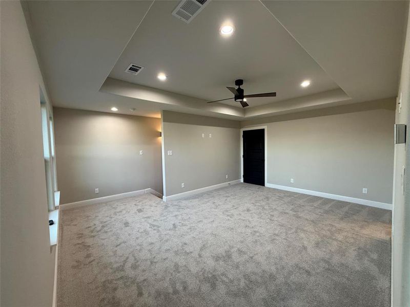 Spare room featuring light carpet, ceiling fan, a raised ceiling, and recessed lighting Spare room featuring light carpet, ceiling fan, a raised ceiling, and recessed lighting