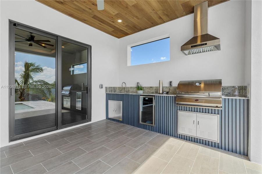 The OUTDOOR KITCHEN includes a BBQ grill, mini refrigerator, and storage - perfect for al fresco dining and entertaining.