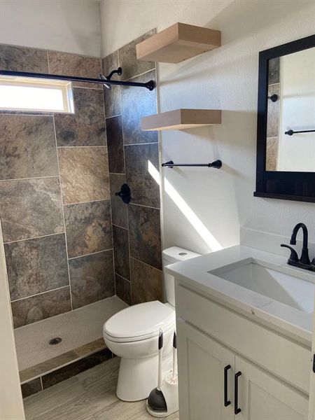 Kitchen with pendant lighting, a center island with sink, white cabinets, light stone countertops, and stainless steel appliances