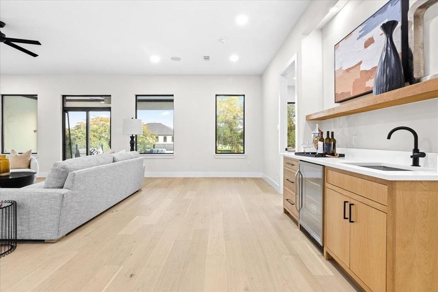 Kitchen with sink, ceiling fan, light hardwood / wood-style floors, and light brown cabinets